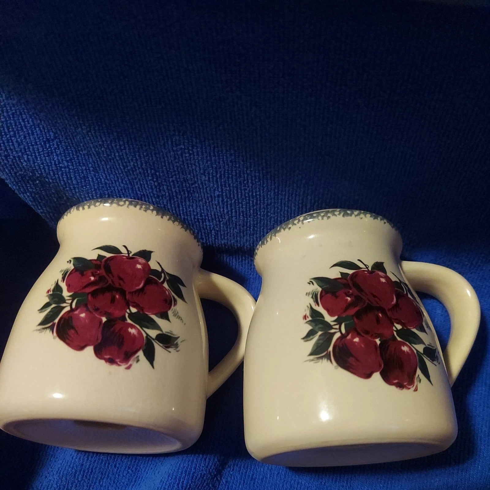 Back Road Vintage Valuables cream stoneware salt and pepper shakers with red apple design and scalloped rim.
